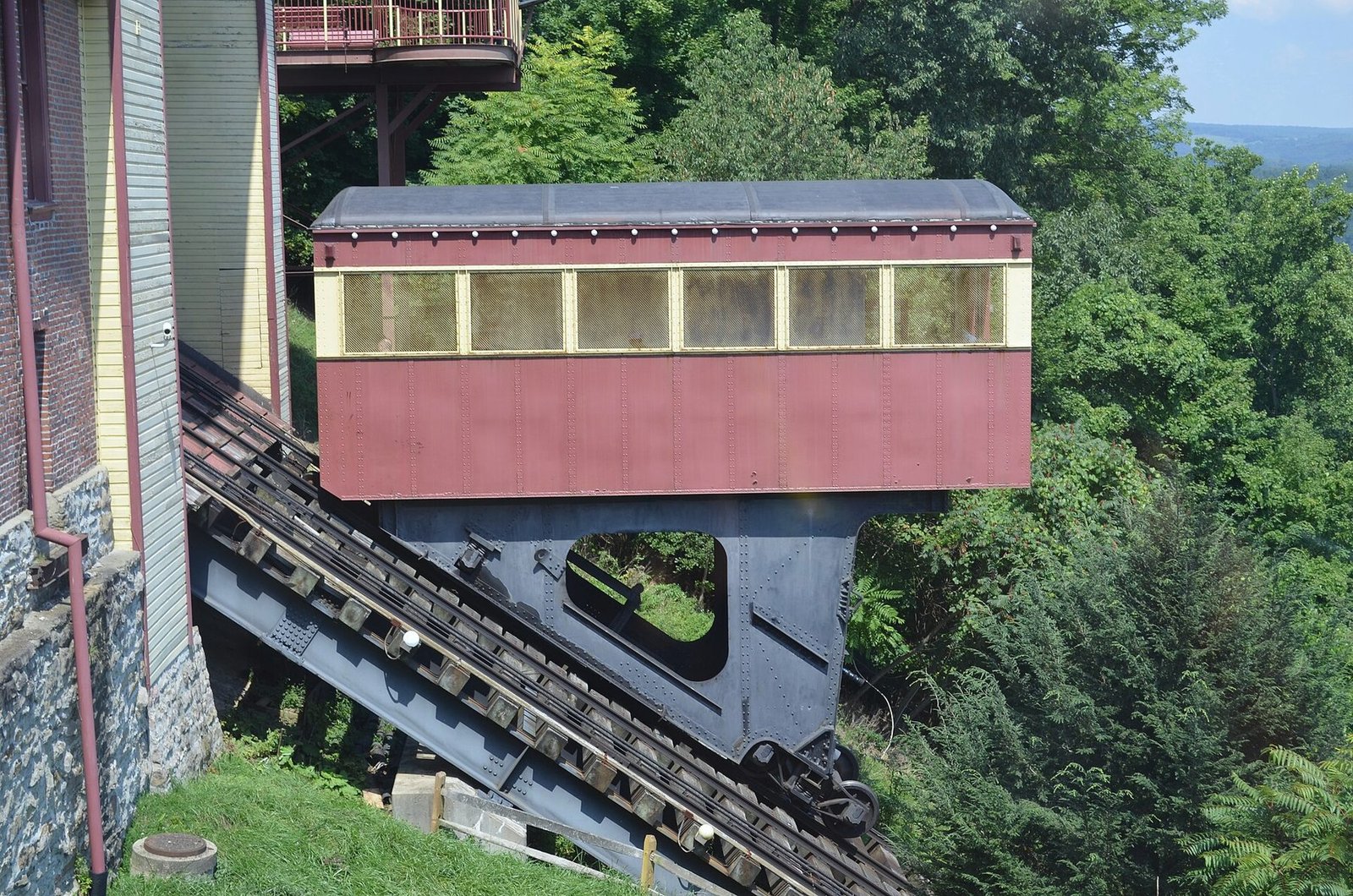 The dark red car of the Johnstown Inclined Plane on its steep steel track among trees