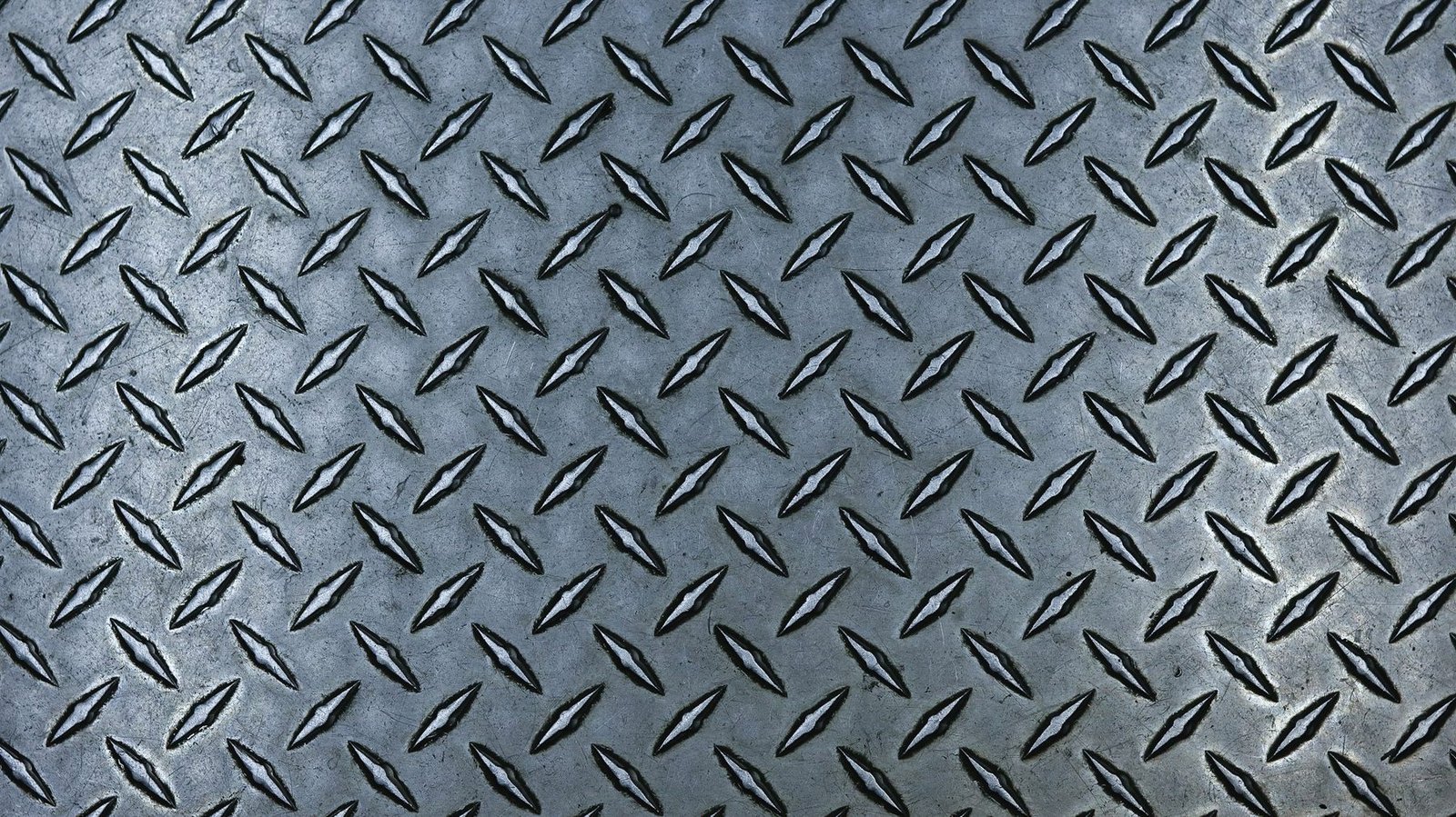 Close view of steel tread plate with a raised diamond pattern